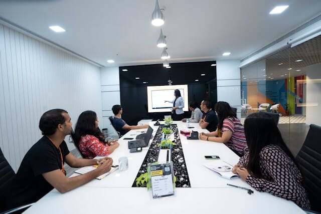 A group of professionals attending a training, learning & Development tutorial in a modern conference room.